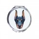 Uno specchio tascabile con un cane Dobermann. Una nuova collezione con il cane geometrico
