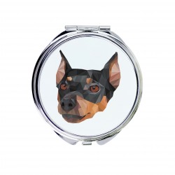 Un espejo de bolsillo con un perro Pinscher alemán. Una nueva colección con el perro geométrico